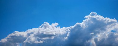 Üst yarısında açık gökyüzü ve mavi gökyüzü olan gri Cumulus bulutları..