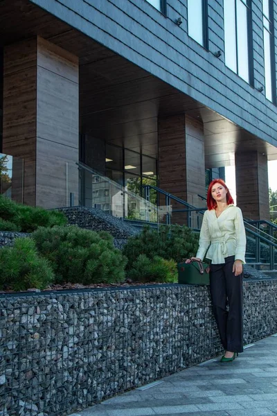 İş merkezinin yakınında kızıl saçlı güzel bir iş kızı.