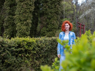 Çekici bir kız parkta yürüyor. Dinlenme ve seyahat konsepti