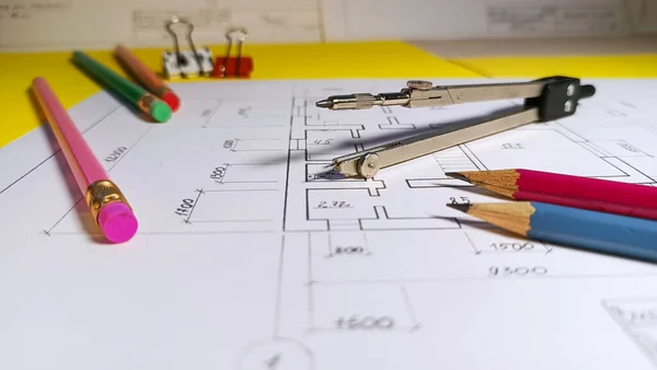 Kalemler, pusula ve diğer araçlarla kağıda yakın plan çizimi. Kararla inşaat planlaması