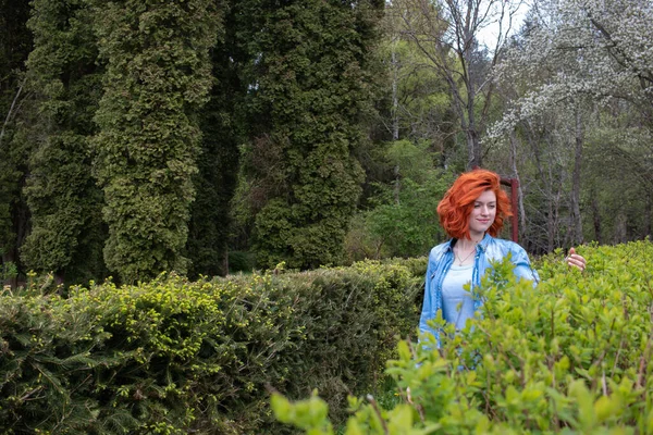 Çekici bir kız parkta yürüyor. Dinlenme ve seyahat konsepti