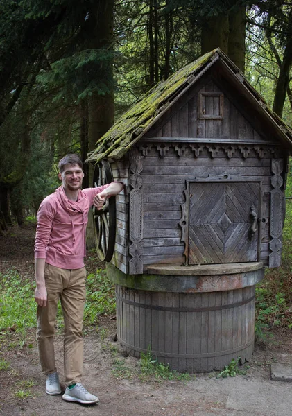 Eski bir kuyunun yanında, doğa koruma alanı, seyahat ve dinlenme konseptinde bir adam.