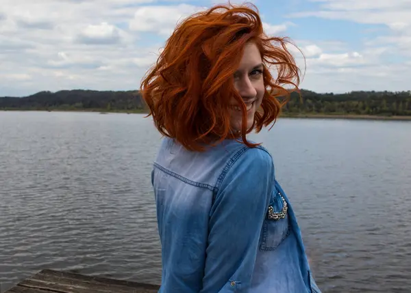 Mutlu, gülümseyen bir kız güzel bir manzaraya yakından bakıyor.