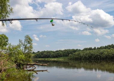 Nehrin arka planında doğayla besleyici çubuk var.