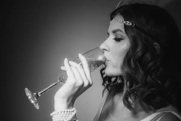 Saçları ve makyajı eski moda olan güzel bir kızın siyah beyaz fotoğrafı.