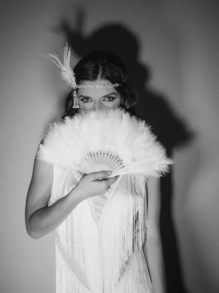 Saçları ve makyajı eski moda olan güzel bir kızın siyah beyaz fotoğrafı.