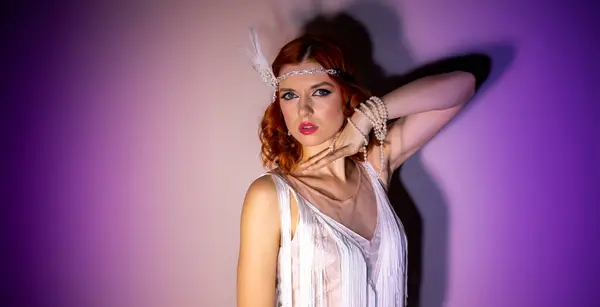 Kırmızı saçlı, makyajlı ve 20 'li yaşlarda güzel bir kız. Mor arka planda beyaz bir elbise giyiyor. Mesaj için yeri var.