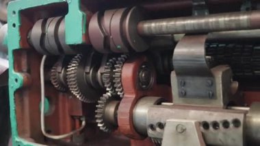 Metal kesme tornası devrede. Besleme mekanizmasını, dişlileri ve kontrolleri kapatın. Atölyenin endüstriyel atmosferi.