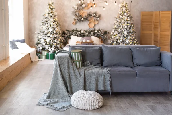 快適なソファとクリスマスツリーとギフトで飾られたベッドとモダンなスタジオリビングルームのインテリア — ストック写真