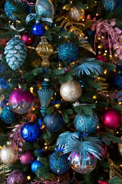 Topları Noel ağacına yakın tut. Arka planda Bokeh çelenkleri. Yeni yıl ve Noel konsepti