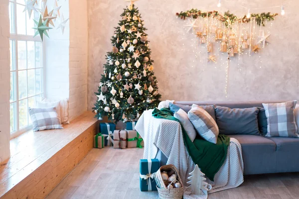 クリスマスツリーやギフトで飾られた快適なソファ付きのモダンなスタジオリビングルームのインテリア — ストック写真