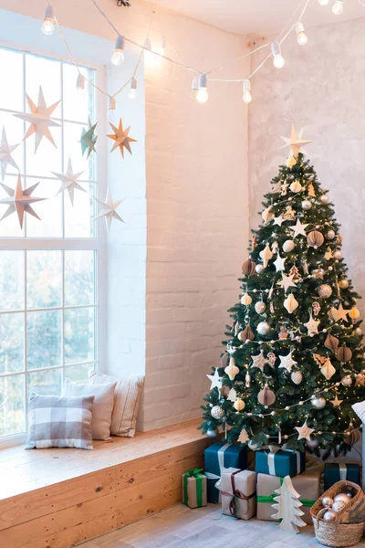 クリスマスツリーやギフトで飾られた快適なソファ付きのモダンなスタジオリビングルームのインテリア 垂直画像 — ストック写真