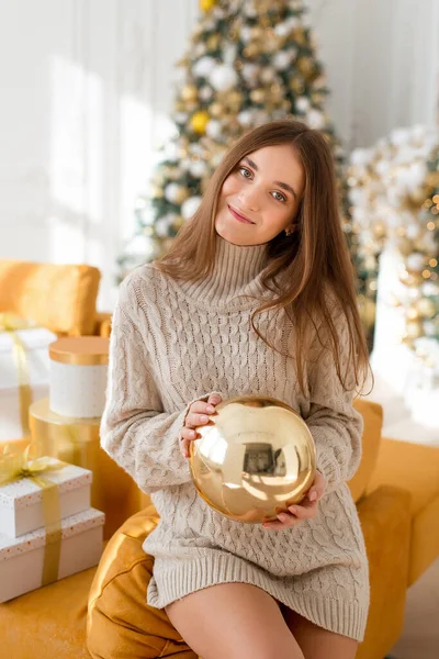 クリスマスを祝う幸せな若い美しい女性 女の子でセーターでポーズのクリスマスツリーの背景 — ストック写真