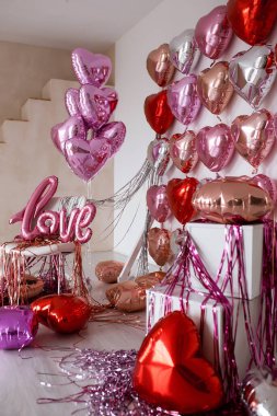 Festive decorations for Valentines day, wedding or hen party. Love sign and heart shape balloons on white background