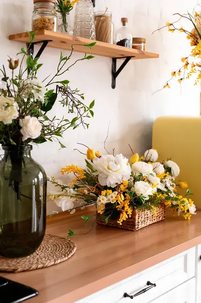 木製のテーブルの上に花の花束 背景には スカンジナビアスタイルの白いキッチンのインテリア 家の快適さのコンセプト ロイヤリティフリーのストック画像
