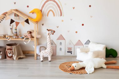 Çağdaş bir çocuk odası, İskandinav tarzı. Tahta yatak, kanepe ve oyuncaklar. Çocuklar için rahat bir oda