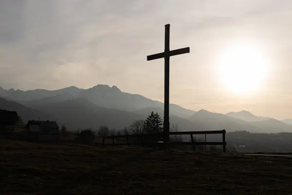 宗教のテーマ カトリックの十字のシルエットの眺め 素晴らしい日没と山を背景として トーンされたイメージ ストックフォト