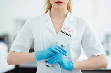Genç bir bilim adamı deneyler için modern bir araştırma laboratuvarında çok kanallı bir pipet kullanırken görülüyor.