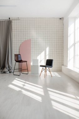 İki çağdaş sandalye minimalist bir duvara yaslanmış, modern mimari tasarımı mükemmel bir şekilde sergiliyor.