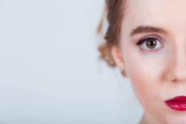 Bu fevkalade bir yarım yüz portresi yumuşak, bulanık bir arka plana karşı zarif makyaj sanatını sergiliyor.