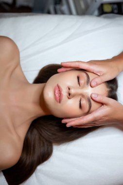 Rahatlamayı ve cilt bakımını canlandırma tekniklerini vurgulayan sakinleştirici ve dingin bir yüz tedavisi seansı