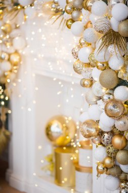 Beyaz bir sandalye, güzel dekore edilmiş bir ağaç ve zarif altın aksanları olan rahat ve şık bir tatil ortamı.