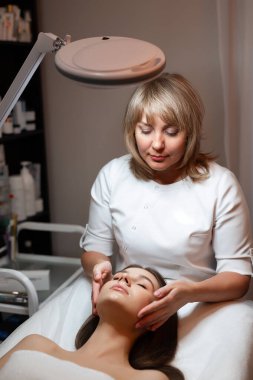 Yetenekli bir güzellik uzmanı, sakin ve huzurlu bir spa ortamında müşterisine rahatlatıcı bir yüz tedavisi uygular..