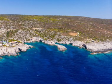 Drone shot of Zakynthos island with beautiful turquoise Ionian sea and limestone cliffs and cave at Porto Limnionas beach during daytime near Blue Caves in Greece