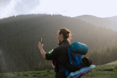 Genç yürüyüşçü Ukrayna 'nın Karpat Dağları' nda selfie çekiyor. Doğa ve teknolojinin birleştiği huzurlu bir an..