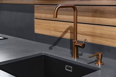 Mutfakta siyah lavabo ve musluk var.
