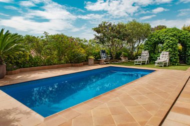 Bahçede yüzme havuzu ve yeşil çimenler var.