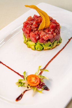 Beyaz tabakta ton balığı ve avokado tartar.