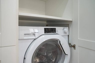 Dolapta modern çamaşır makinesi var.