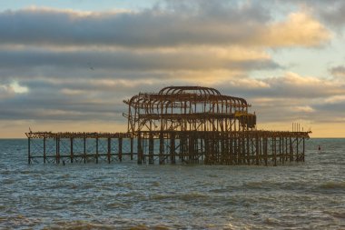Doğu Sussex, İngiltere 'deki Brighton' daki Batı İskelesi 'ni mahvetti. Akşam gün batımı ışığı.