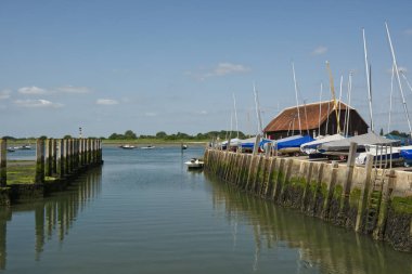 Chichester Limanı 'ndaki Bosham Quay limanında, Batı Sussex, İngiltere. Bağlı tekneler ve alçak gelgitlerle. 