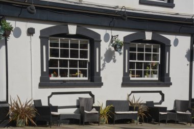 Wicker Koltukları ve Midhurst, West Sussex, İngiltere 'deki otelin dışındaki masalar. Beyaz boya duvarları ve kuşak pencereleriyle. 