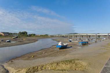 Batı Sussex, İngiltere 'de Shoreham' daki Adur Nehri üzerindeki demiryolu köprüsü. Çamurda karaya vurmuş tekneler.