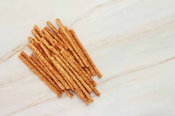 dry long bread sesame sticks on a gray marble background