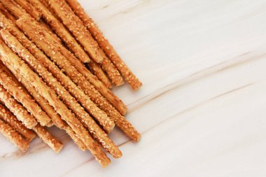 Gri mermer arka planda uzun susamlı ekmek çubukları