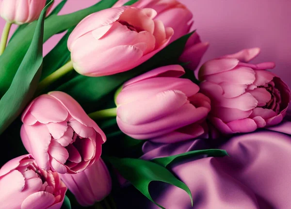 Bouquet of festive pink tulips with green leaves on a pink background.  Generative AI, generative artificial intelligence