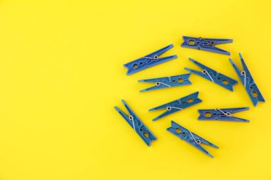 Plastic clothespins for attaching clean laundry to a rope, yellow background