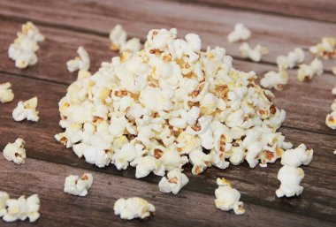 White fried popcorn on a brown wooden background