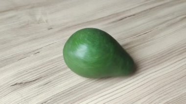 Ahşap arka planda doğal yeşil avokado.