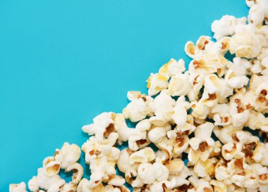 Mavi arka planda kızarmış beyaz patlamış mısır.