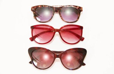 Beyaz arka planda plastik çerçeveli kadın güneş gözlüğü.