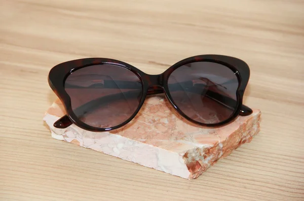Óculos Sol Femininos Uma Moldura Plástico Fundo Marrom — Fotografia de Stock