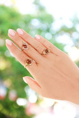 Women's jewelry gold ring with a gemstone on the finger of the hand