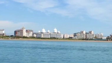 Antalya, Türkiye, 11 Mayıs 2023. Güzel mavi Akdeniz, sahildeki büyük otel binaları