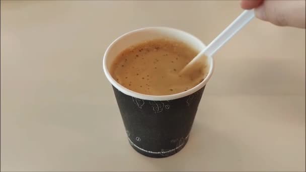 一个白色的塑料勺干扰了咖啡卡布奇诺和杯子中的泡沫 — 图库视频影像