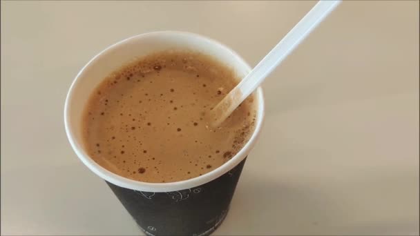 Белая Пластиковая Ложка Мешает Кофе Капучино Пеной Стакане — стоковое видео